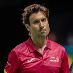 David Ferrer, tenisista w czerwonej koszulce, zamyślony na korcie.