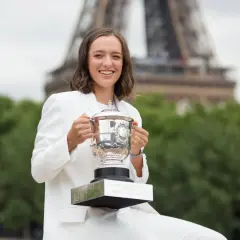 Iga Świątek z pucharem French Open, potwierdzając swoją pozycję w aktualnym rankingu tenisistek. Wieża Eiffla w tle.