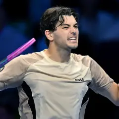 Taylor Fritz, tenisista, triumfuje po wygranym punkcie, zaciskając pięść i unosząc rakietę.