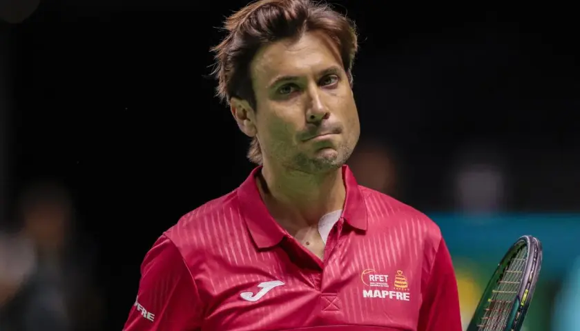 David Ferrer, tenisista w czerwonej koszulce, zamyślony na korcie.