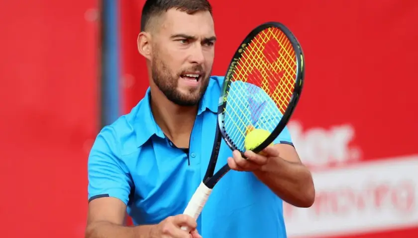 Jerzy Janowicz, z rakietą i piłką, może symbolizować koniec kariery.