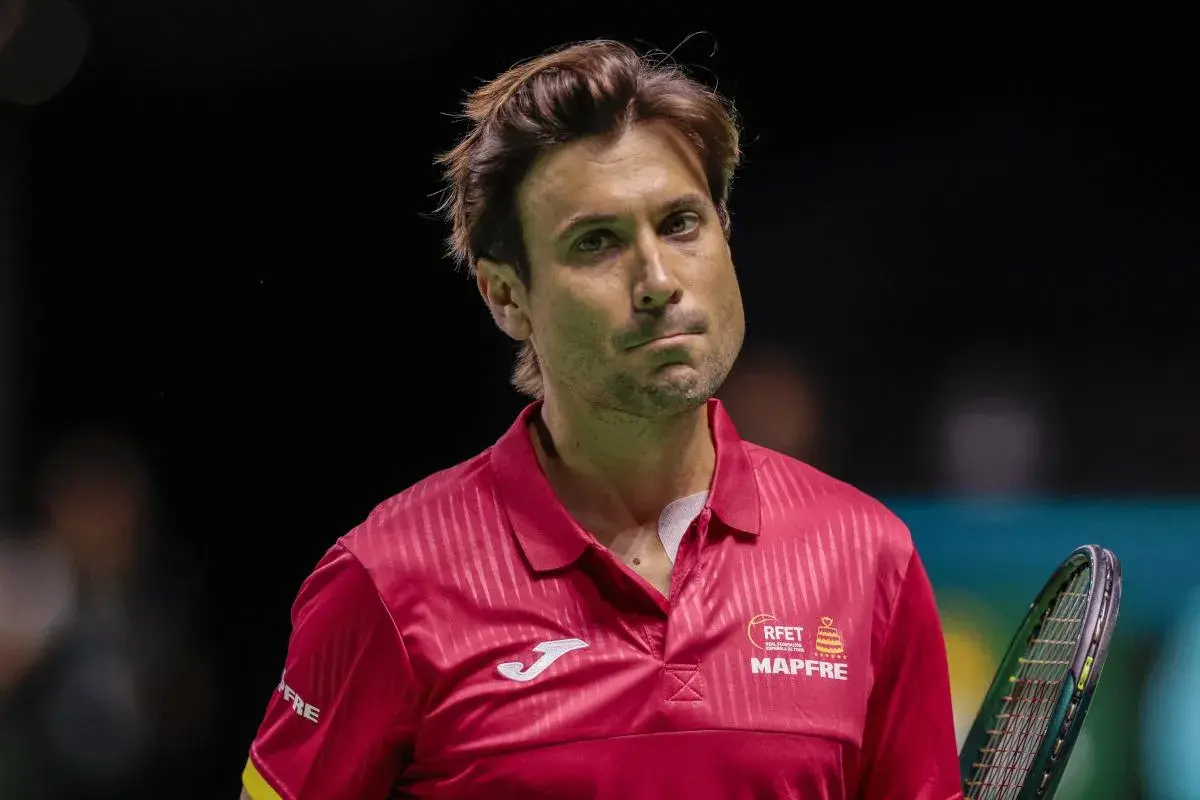 David Ferrer, tenisista w czerwonej koszulce, zamyślony na korcie.