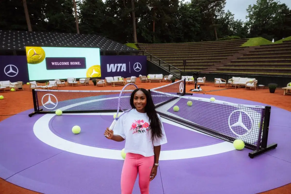 Uśmiechnięta tenisistka na korcie WTA, gotowa do gry. Sędziowie tenisa ziemnego WTA czuwają nad przebiegiem meczu.