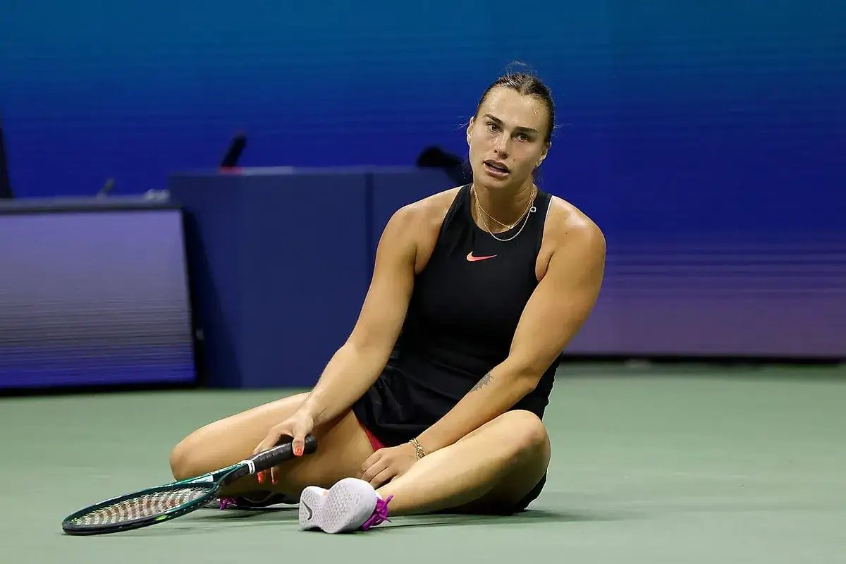 Tenisistka siedzi na korcie po meczu WTA 500, z rakietą obok.