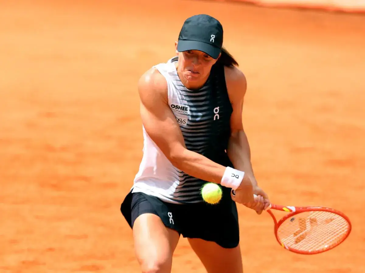 Tenisistka w akcji podczas turnieju WTA, skupiona na odbiciu piłki.